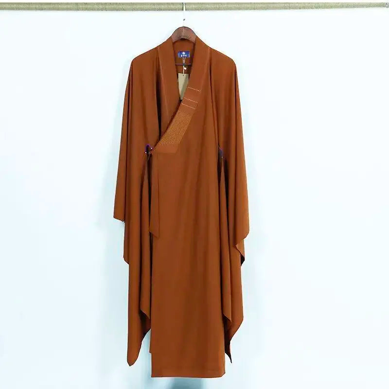 Robe de méditation bouddhiste ocre sur cintre, col croisé avec surpiqûres horizontales.