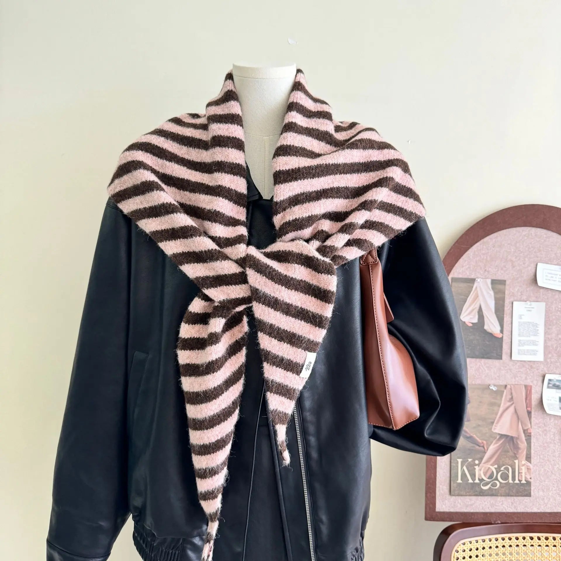 Gros plan sur la maille rayée grise et blanche, soulignant la texture moelleuse de la laine mélangée.