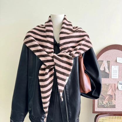 Gros plan sur la maille rayée grise et blanche, soulignant la texture moelleuse de la laine mélangée.