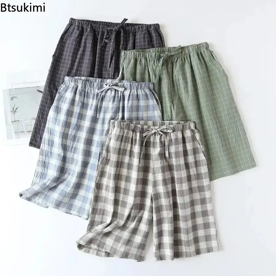 Vue de face de quatre shorts de pyjama homme à carreaux en coton aux teintes gris, vert et bleu.