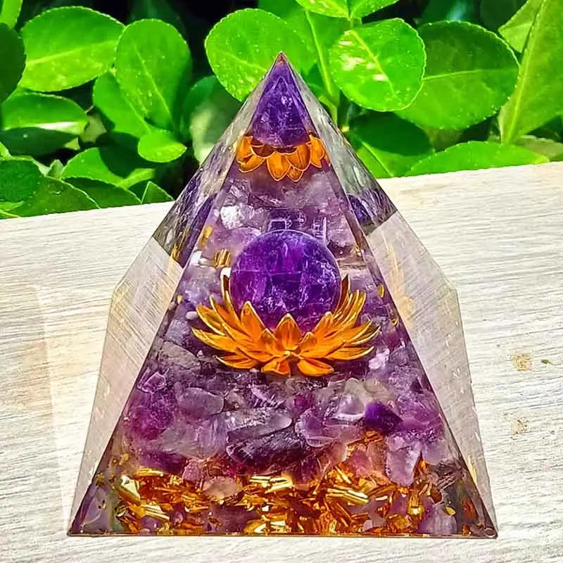 Main présentant une pyramide d'orgonite, soulignant la transparence et la qualité de la fabrication artisanale.