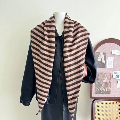 Châle enveloppant à rayures roses et noires, apportant une touche colorée et féminine à l'hiver.