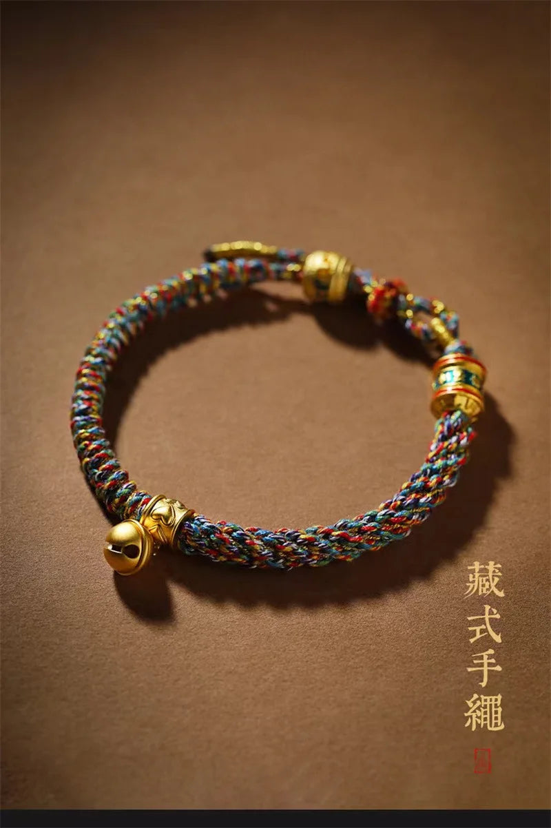 Mains d'artisan tressant avec précision la corde rouge du bracelet porte-bonheur.
