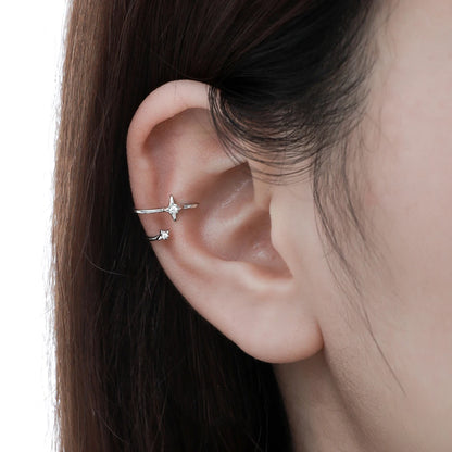 Bague d'oreille étoile en argent portée sur le cartilage d'une femme, ornée de zircons scintillants.