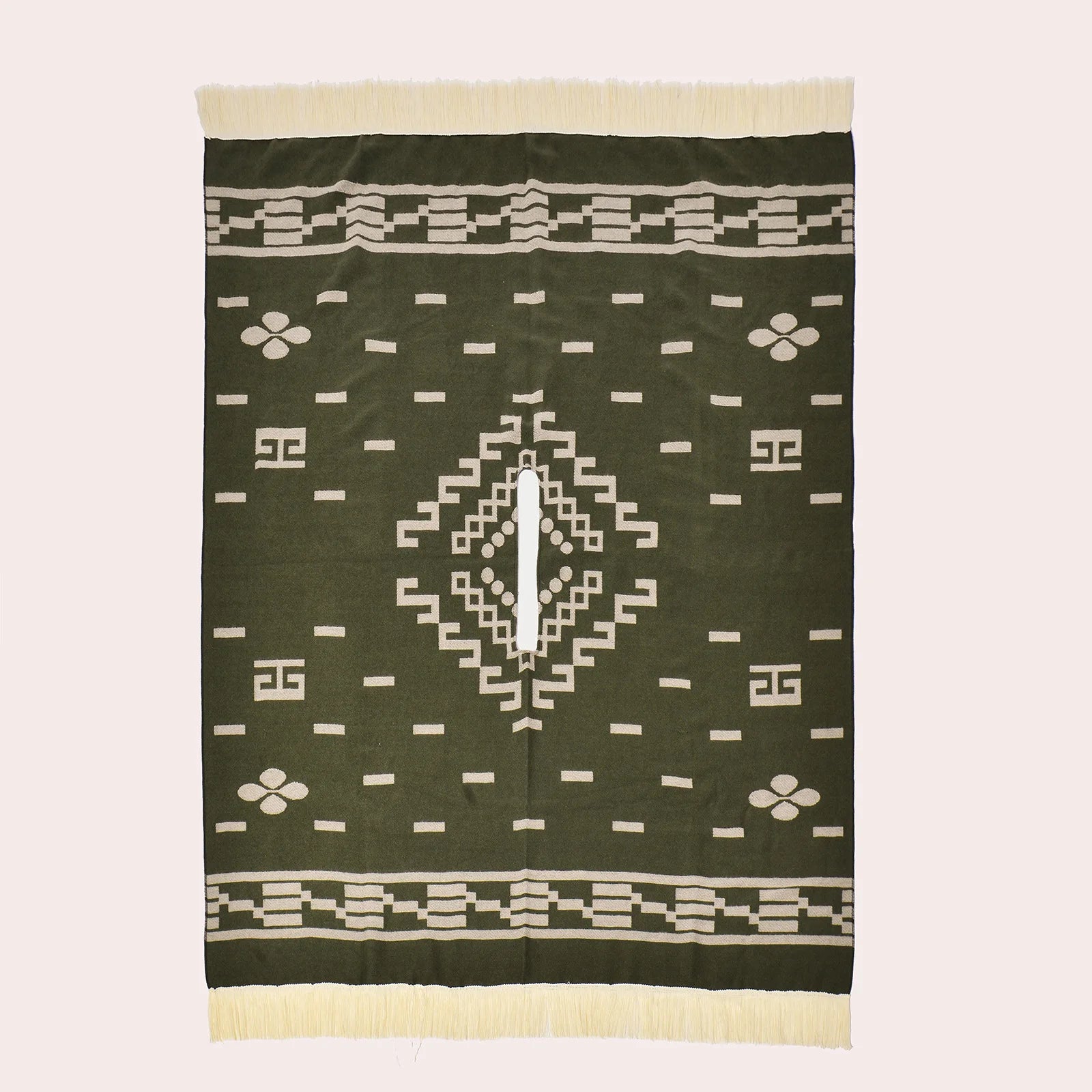 Vue à plat du poncho vert rectangulaire montrant la fente centrale et les motifs géométriques.