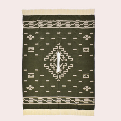 Vue à plat du poncho vert rectangulaire montrant la fente centrale et les motifs géométriques.