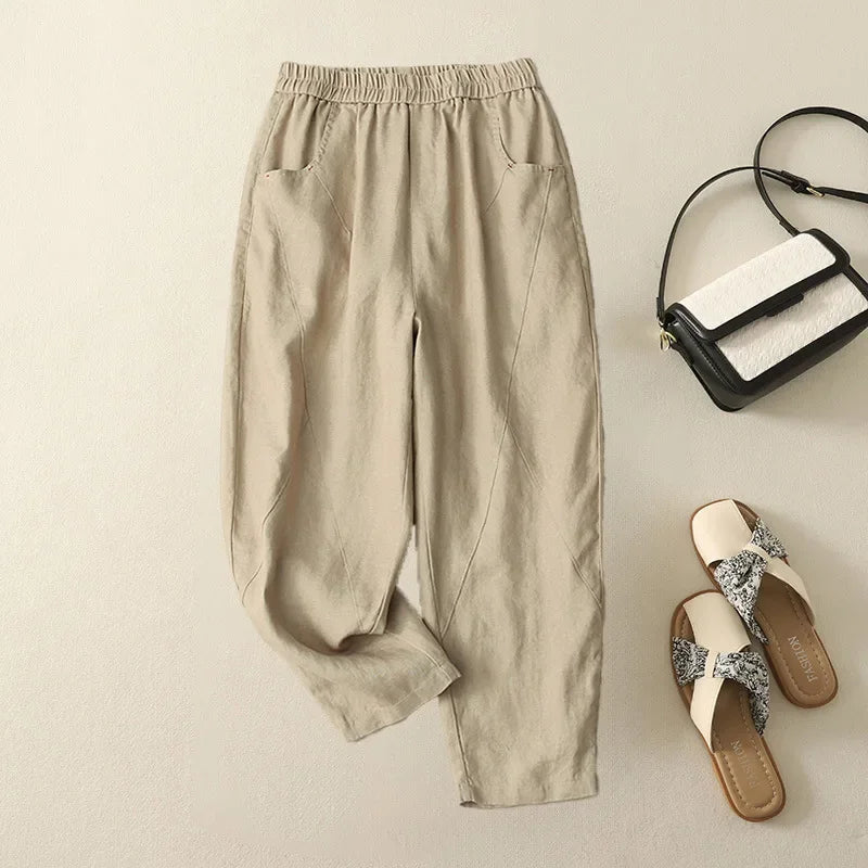 Pantalon harem beige en coton et lin, coupe ample, poches italiennes et coutures obliques sur le devant.