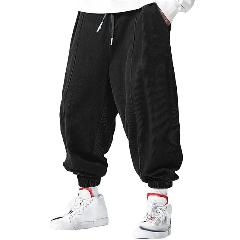 Pantalon large en velours côtelé noir, coupe zen avec cordon de serrage et chevilles resserrées.