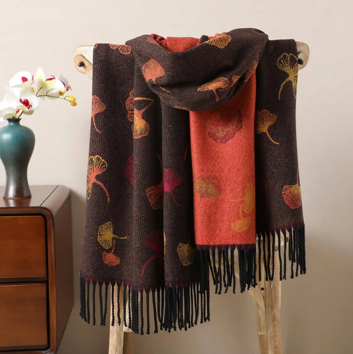 Détail des franges noires et du tissage doux d'une étole réversible aux couleurs automnales.