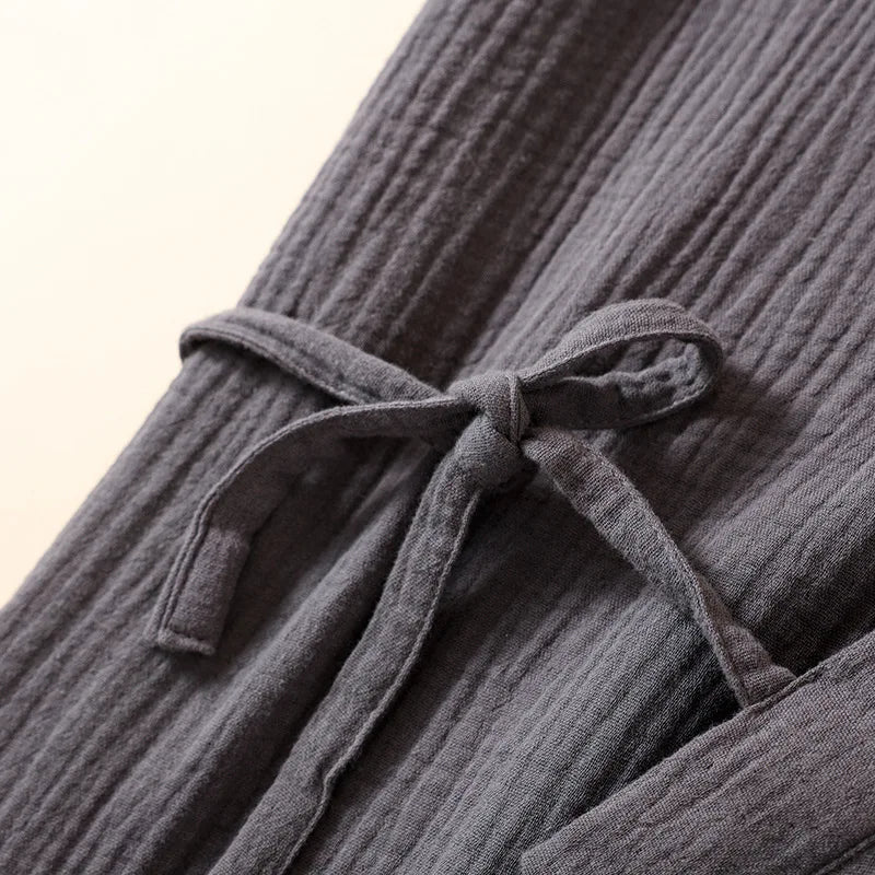 Gros plan sur le nœud de serrage latéral de la robe kimono en coton crêpe gris.