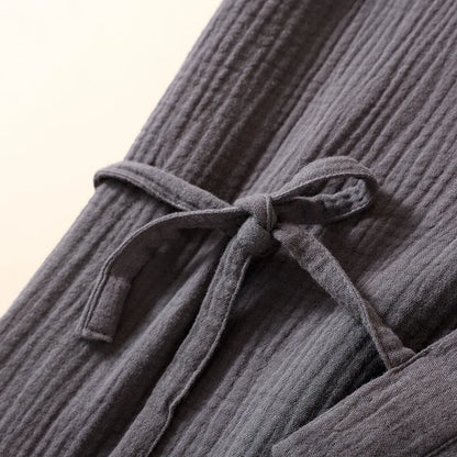 Gros plan sur le nœud de serrage latéral de la robe kimono en coton crêpe gris.