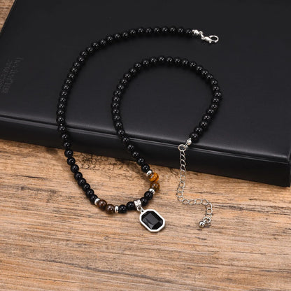 Vue d'ensemble du collier zen pour homme montrant l'alternance des perles noires et des accents marron œil de tigre.