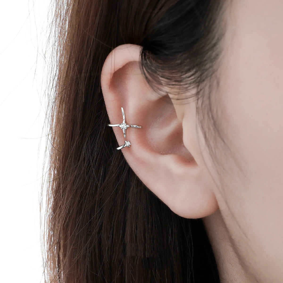 Gros plan de l'ear cuff céleste en argent massif ajusté sur l'oreille, soulignant son éclat discret.