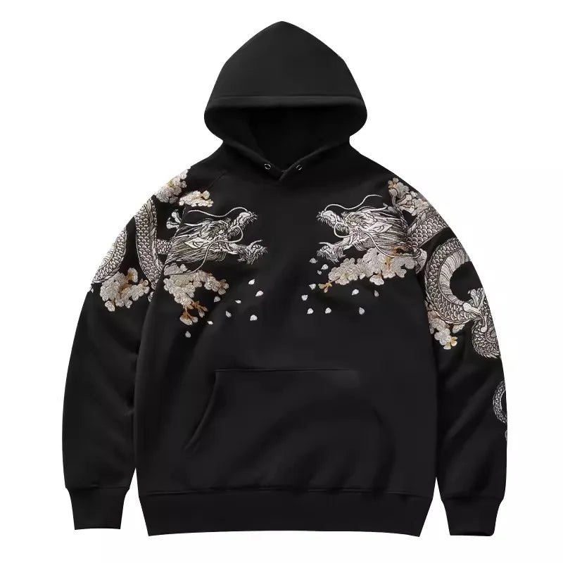 Détail de la face avant du hoodie noir présentant des broderies de dragons symétriques sur le torse et les manches.