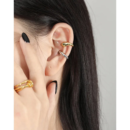 Manchette d'oreille minimaliste en argent et or portée sur le cartilage sans perçage