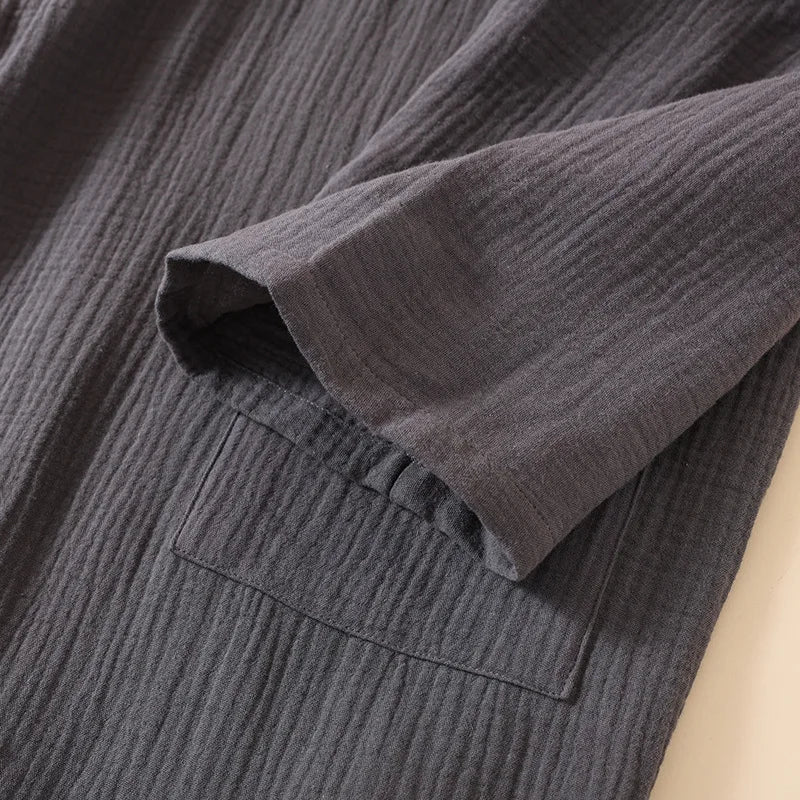 Détail de la finition de la manche et de la poche plaquée sur le tissu gaufré gris.