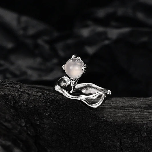 Détail de la manchette d'oreille en argent et pierre naturelle d'agate sur un support minéral sombre