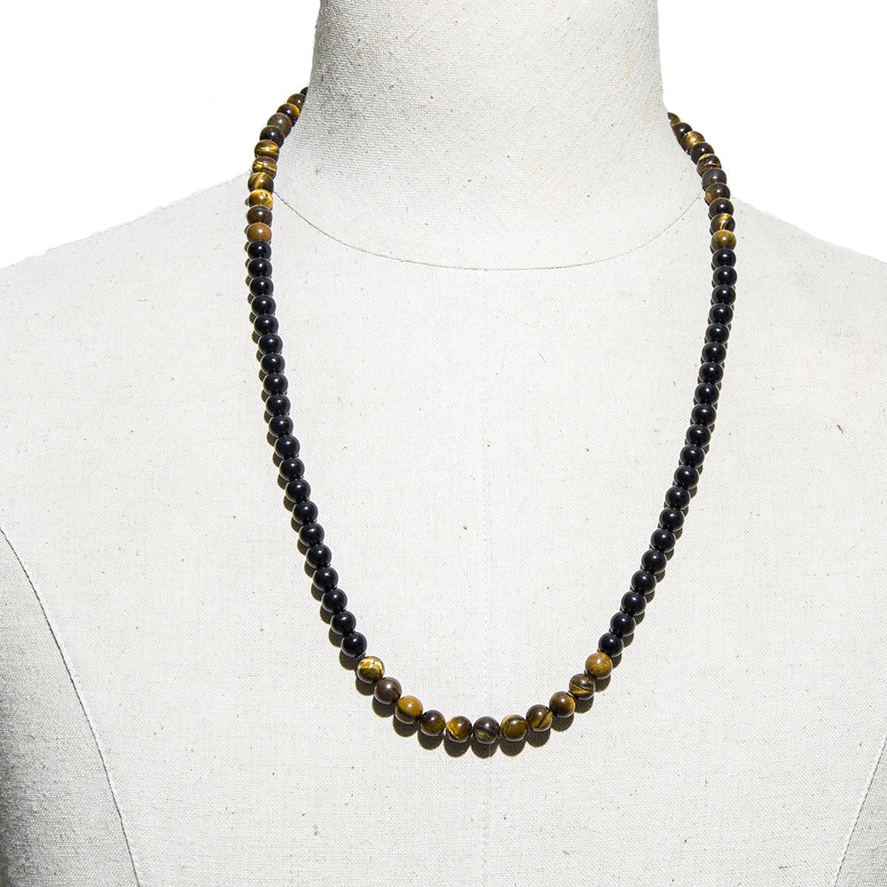 Collier de protection en onyx et œil de tigre présenté sur un buste de mannequin blanc.