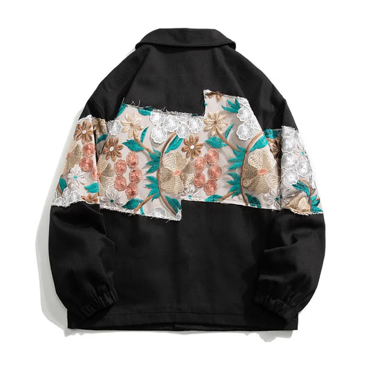 Vue de dos de la veste noire montrant le détail des motifs de fleurs brodées et la coupe ample structurée.