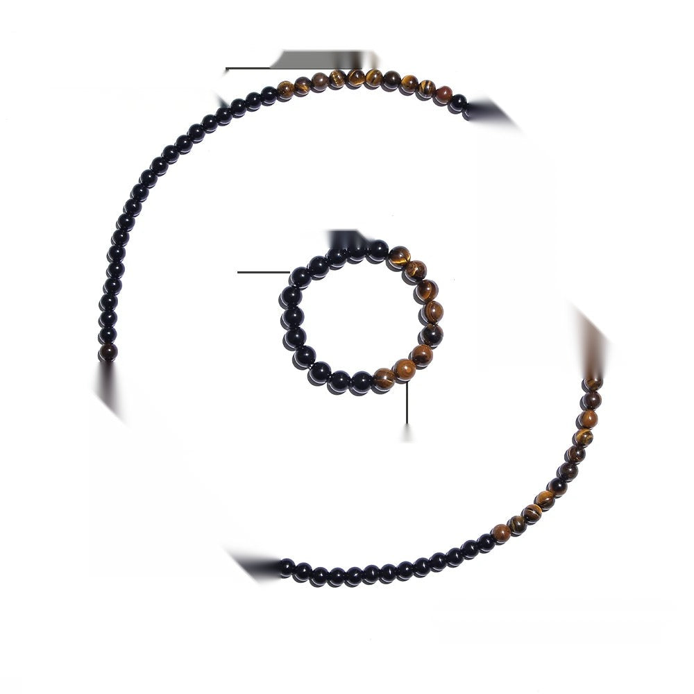 Gros plan sur les reflets dorés des perles d'œil de tigre et le noir profond de l'onyx.