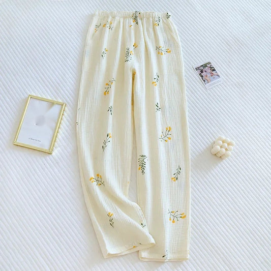 Pantalon de pyjama en coton crêpe ivoire avec motifs fleurs jaunes et feuilles vertes, vue à plat.